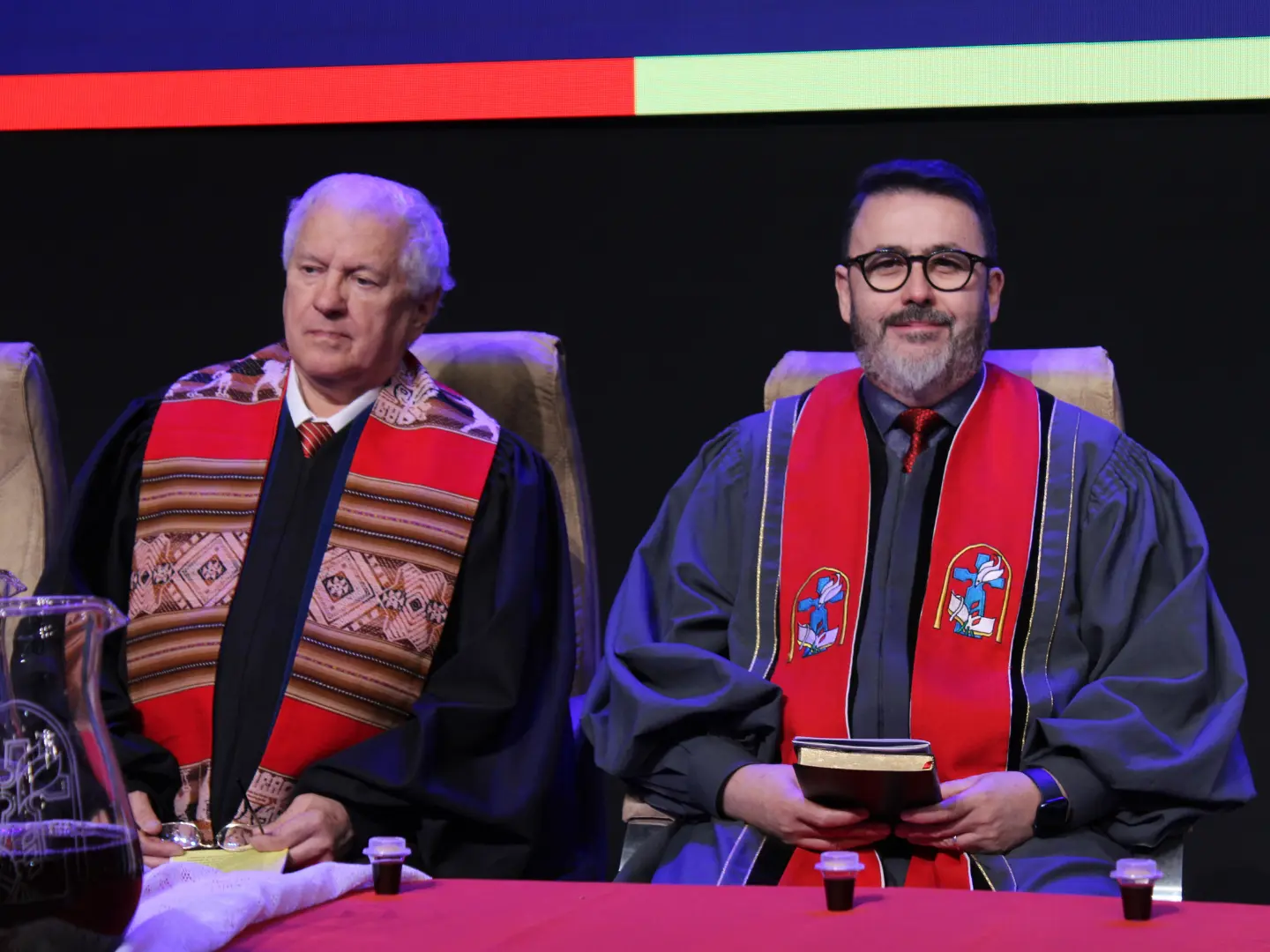 Rev. Gerson Correia de Lacerda em culto solene, de beca, ao lado de outro pastor